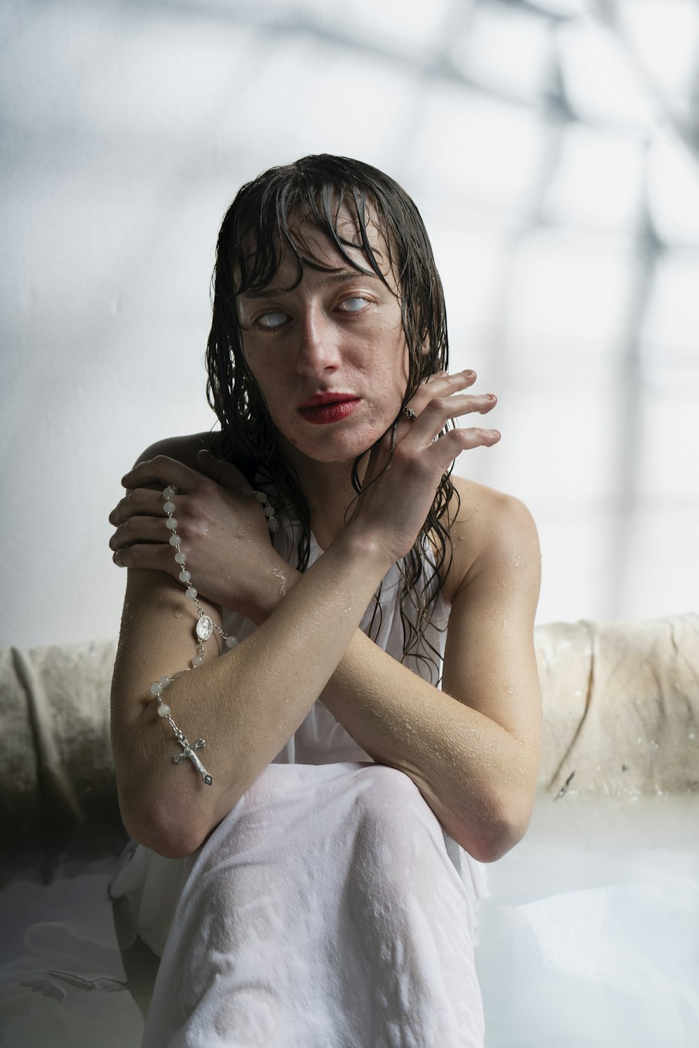 a woman sitting in a bathtub with her hands on her chest