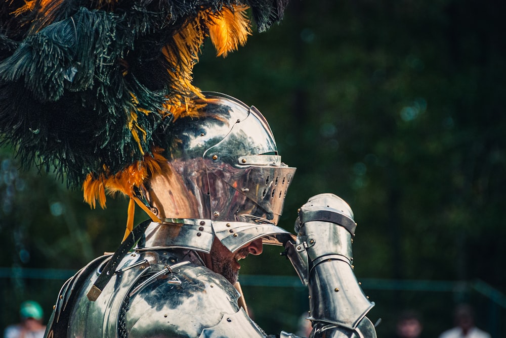 un gros plan de l’armure d’un chevalier avec des plumes dessus