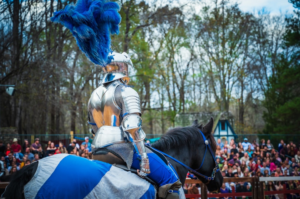 um homem vestido com armadura montado no lombo de um cavalo