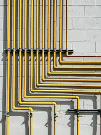 Yellow plastic drainage pipes neatly arranged on a warehouse floor.