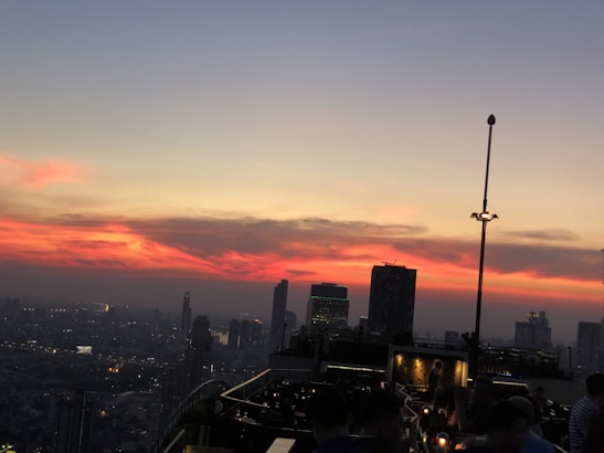 A vibrant cityscape at sunset with people enjoying the nightlife.