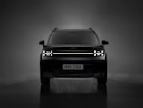 the front of a black suv in a dark room