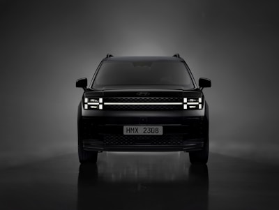 the front of a black suv in a dark room