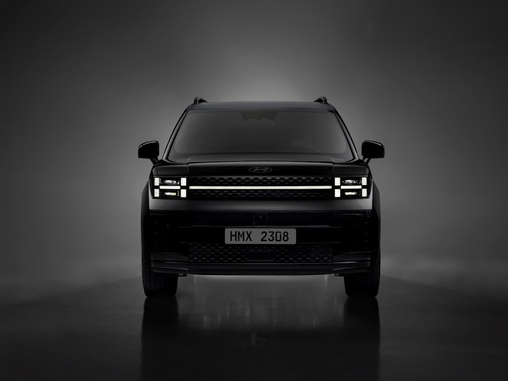 the front of a black suv in a dark room