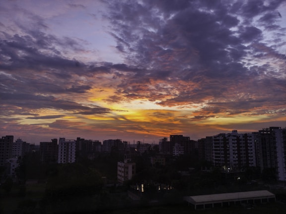 A vibrant sunset over a skyline filled with innovative tech buildings.
