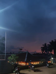 Evening scene with warm lights glowing from homestay rooms.