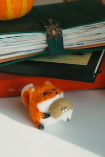 A cheerful felt fox with stitched eyes and a heart-shaped patch on its chest.