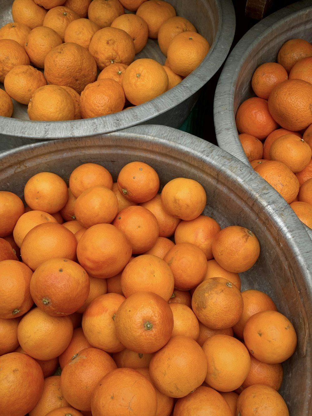 three buckets filled with oranges sitting next to each other