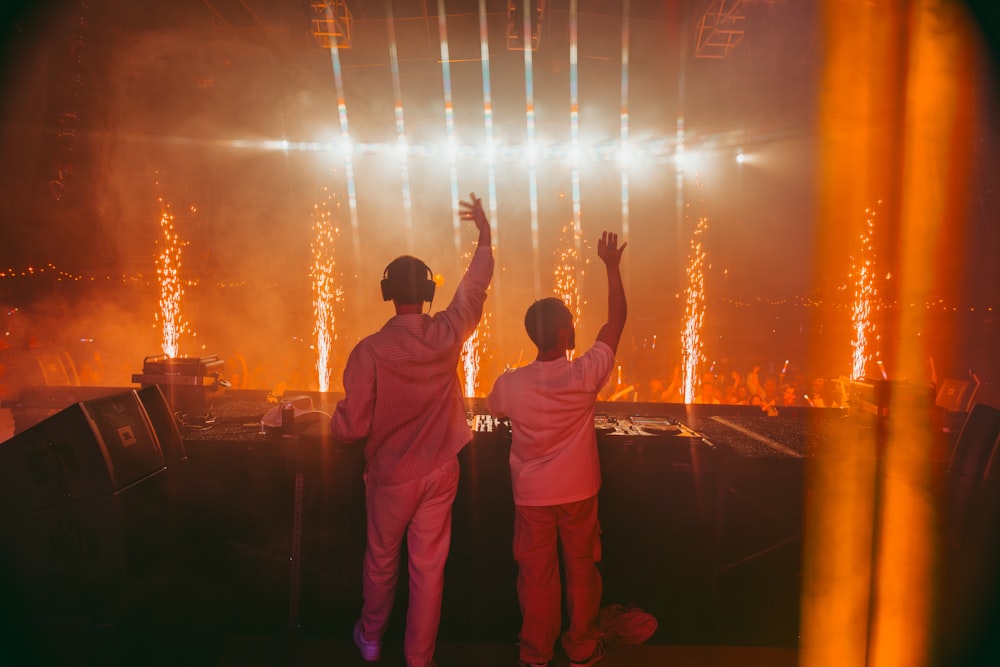 a couple of people that are standing in front of a stage