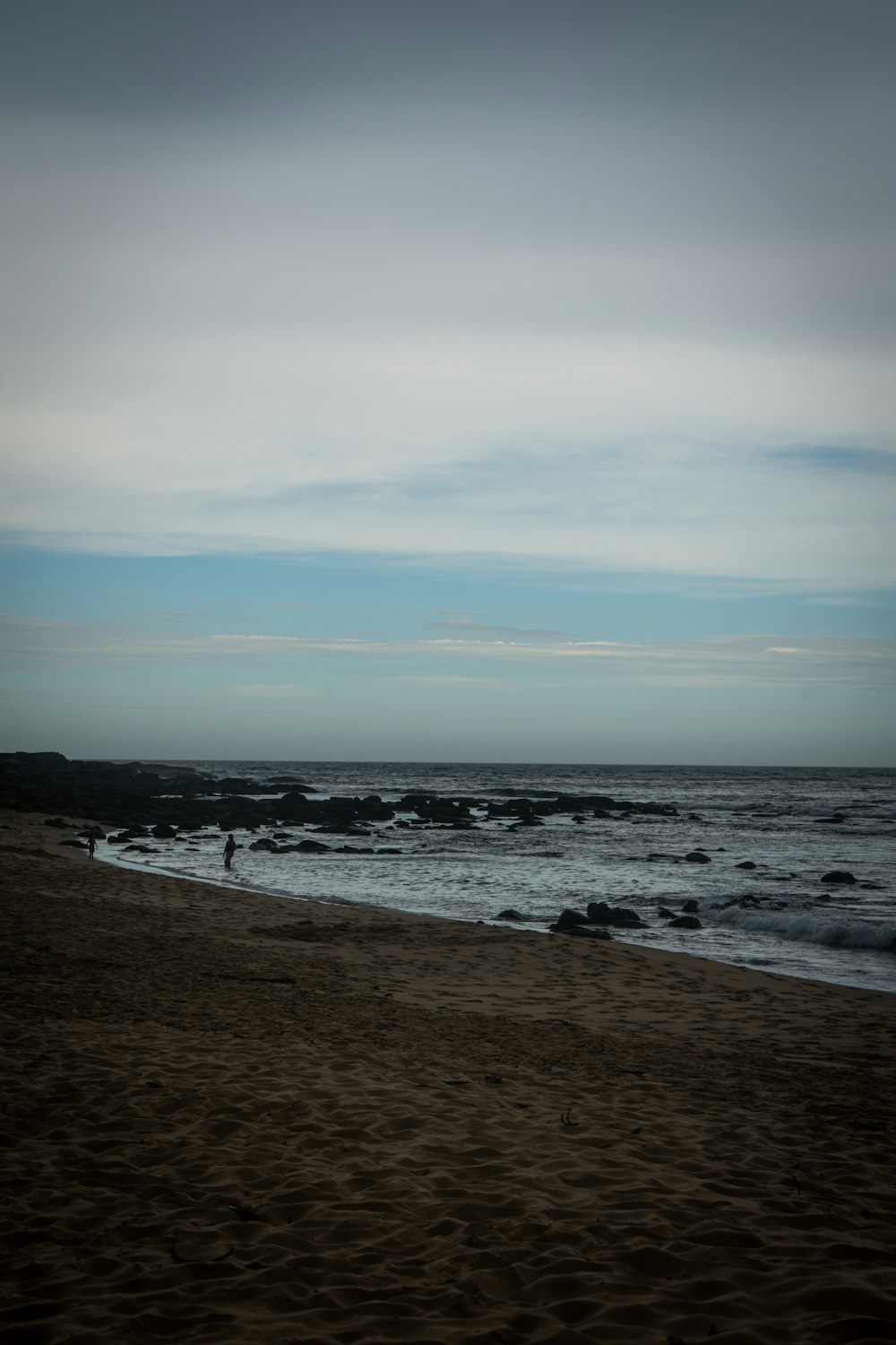 a person standing on a beach next to the ocean