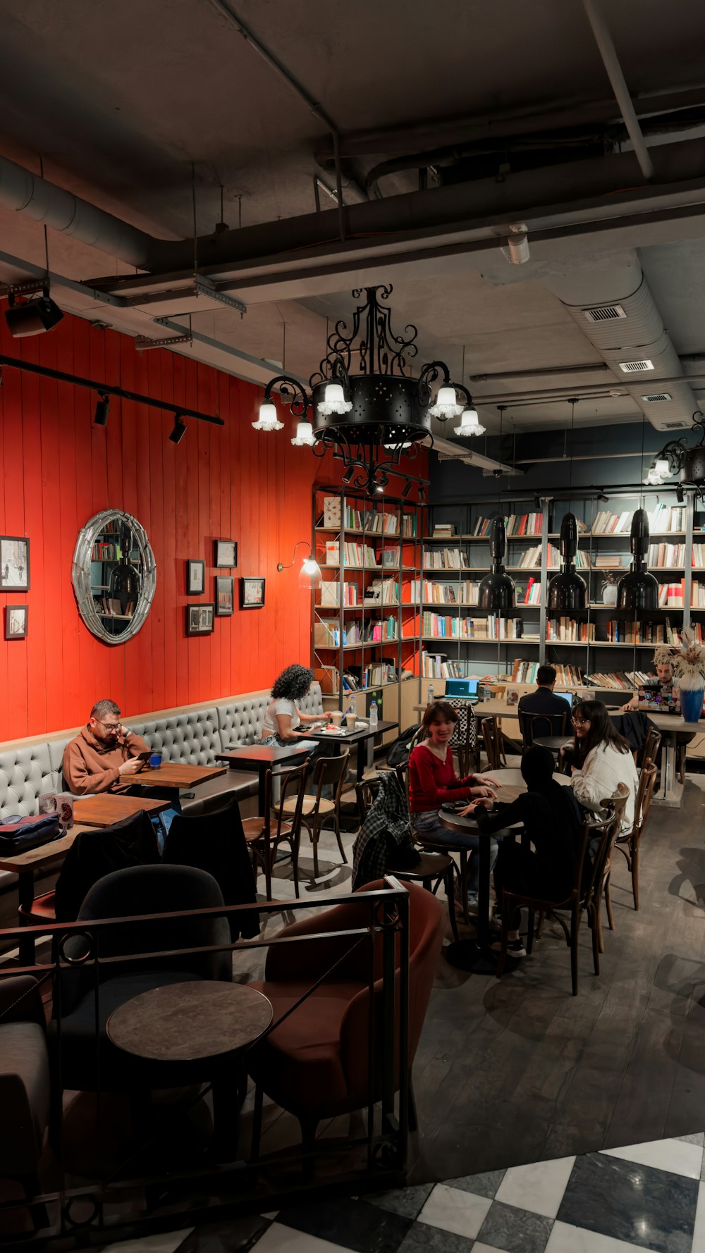 a group of people sitting at tables in a library