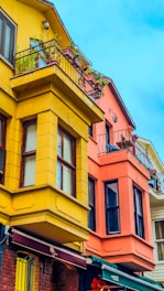 Vibrant house facade painted in warm, cheerful colors under a clear blue sky.