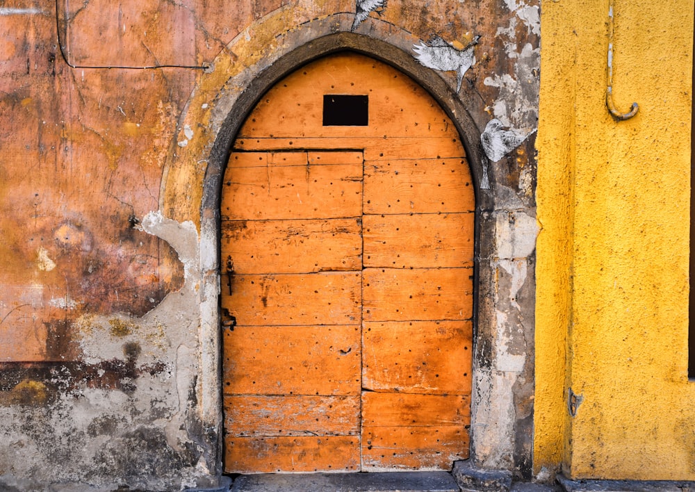 an old yellow door with a stone arch