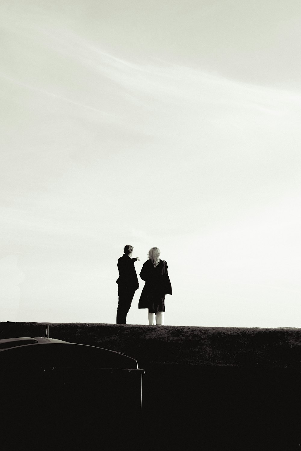 a couple of people standing on top of a hill