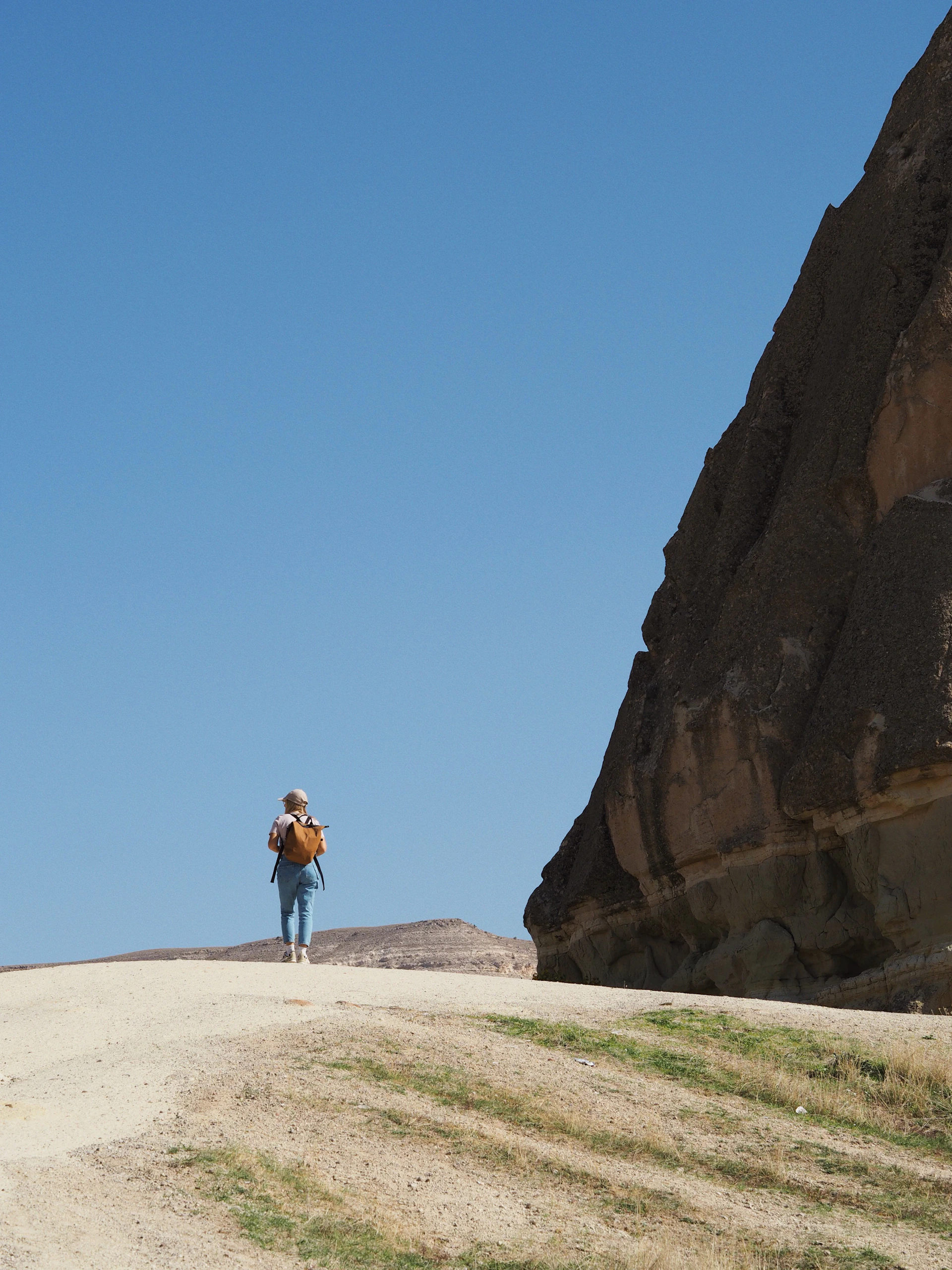 Close-up of a hiker wearing the hypershell exoskeleton, walking comfortably along the rocky path of Morskie Oko under a bright blue sky.