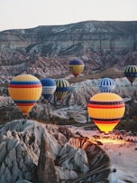 a group of hot air balloons flying over a valley