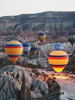 a group of hot air balloons flying over a valley