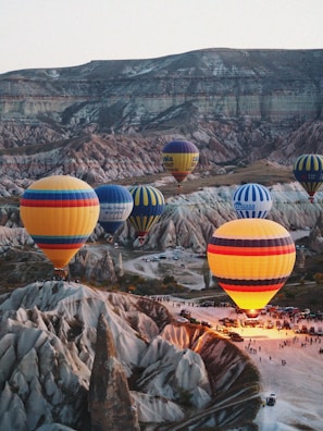 a group of hot air balloons flying over a valley