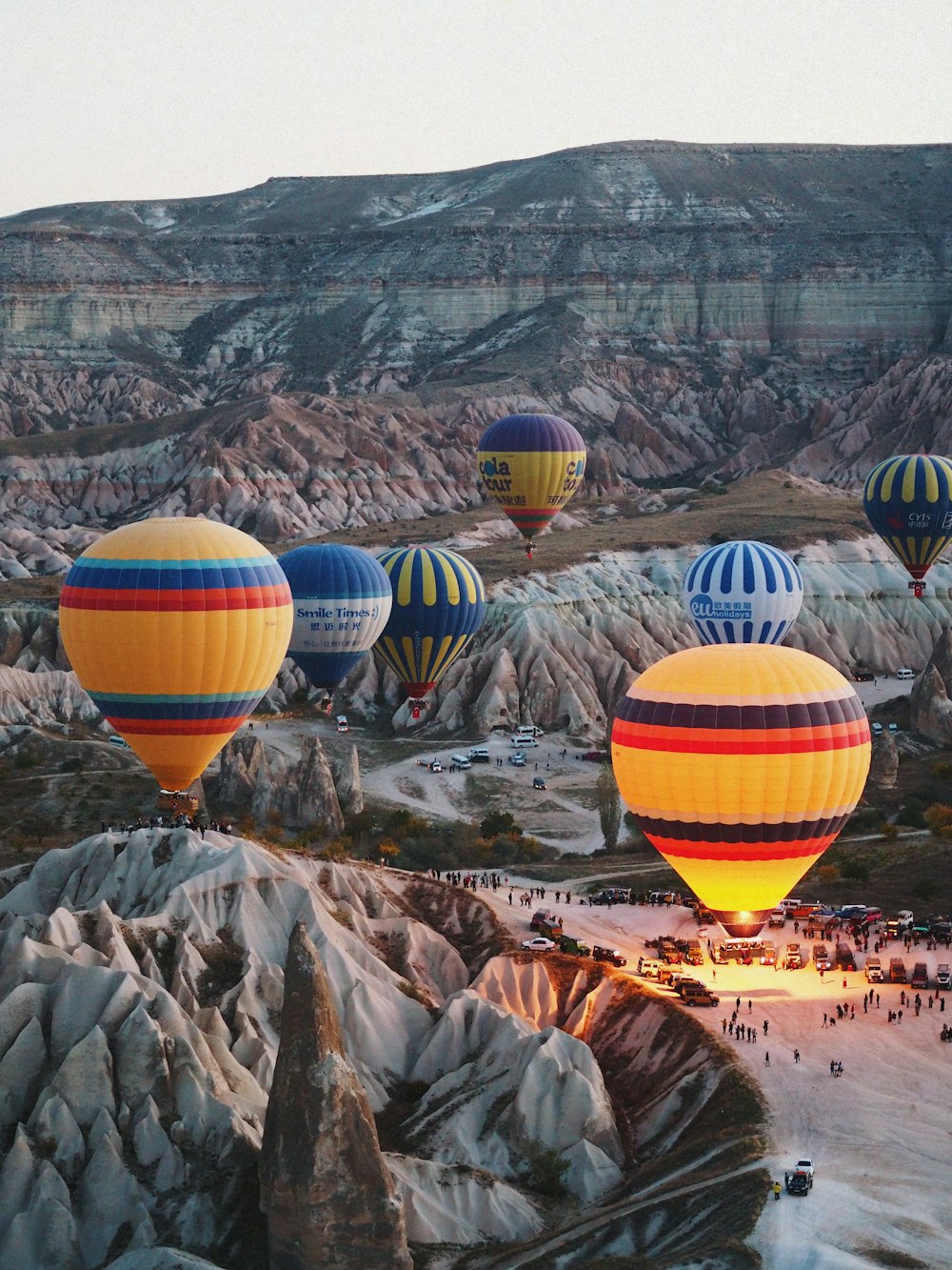 a group of hot air balloons flying over a valley