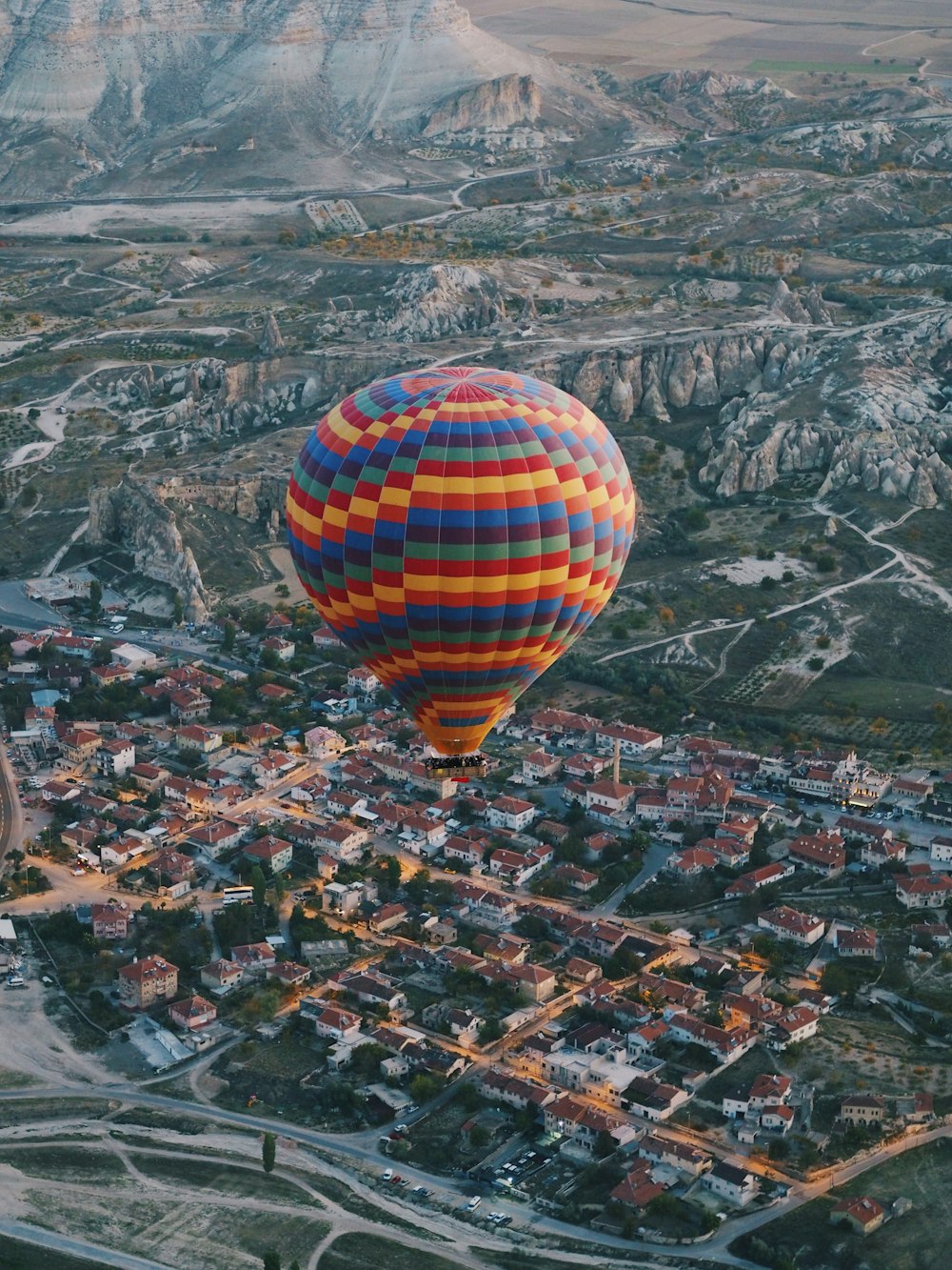 a hot air balloon flying over a small town