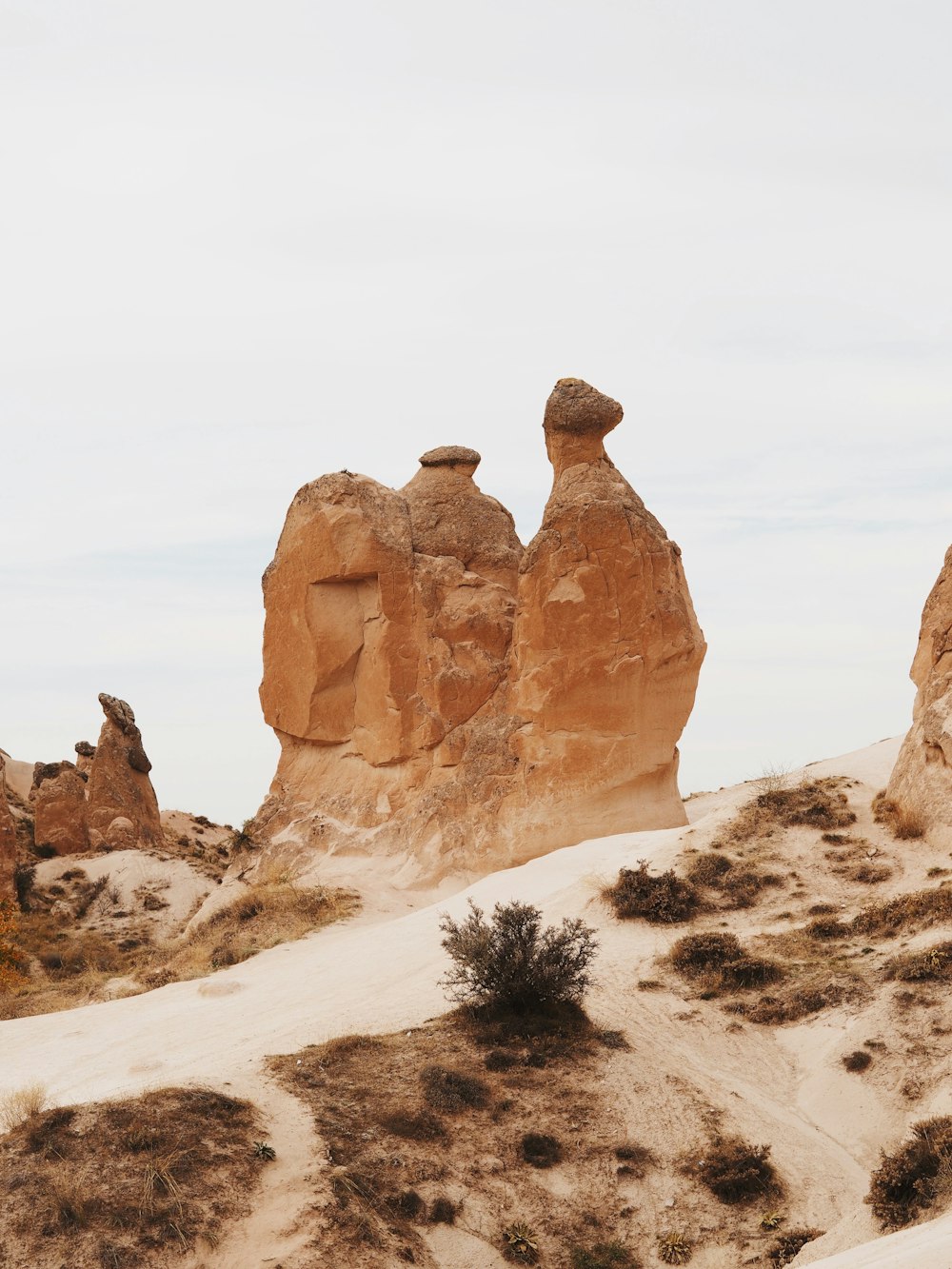 un grupo de rocas sentadas en la cima de una colina arenosa