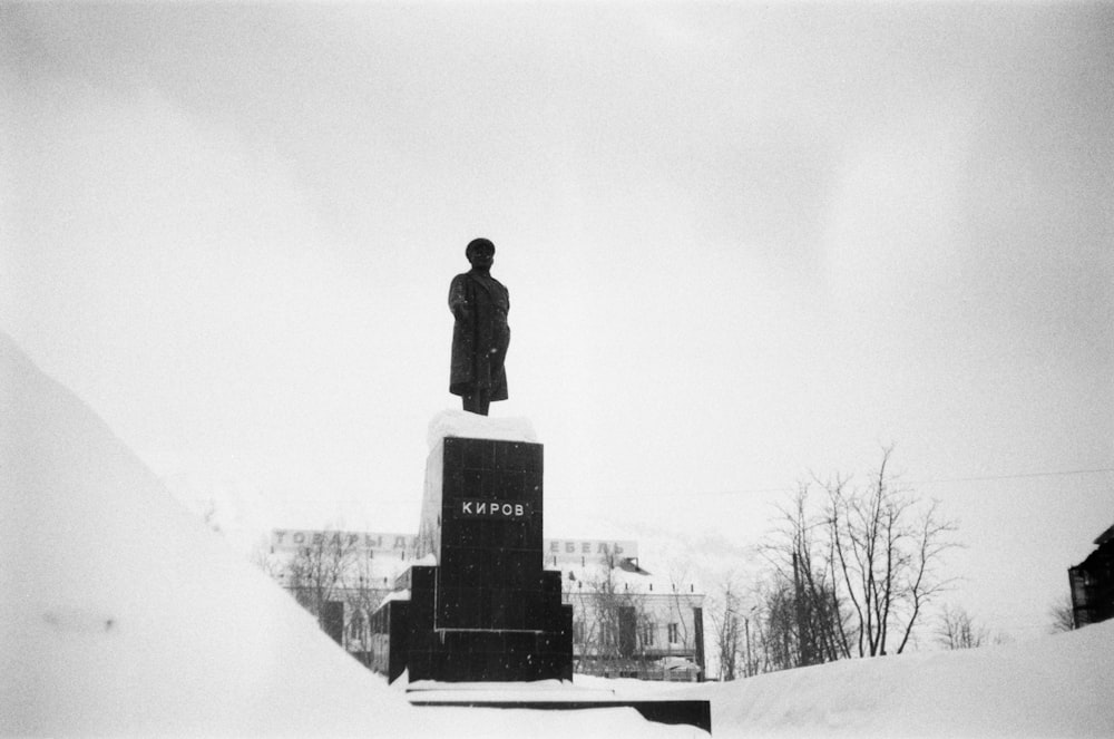 a black and white photo of a statue in the snow