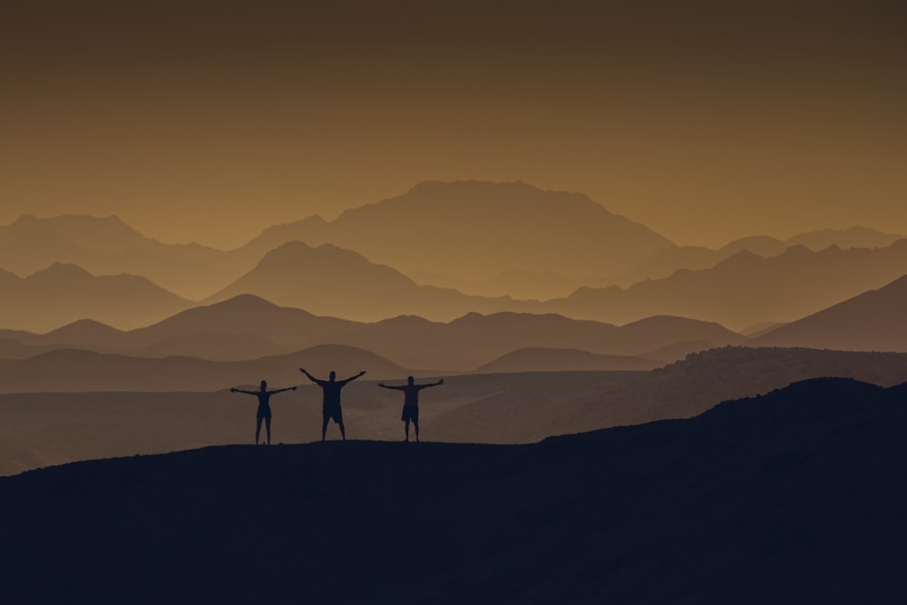 a couple of people standing on top of a mountain