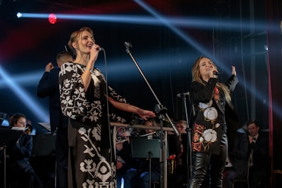 Classically trained duo performing a modern pop cover on stage with minimalist black and white backdrop.