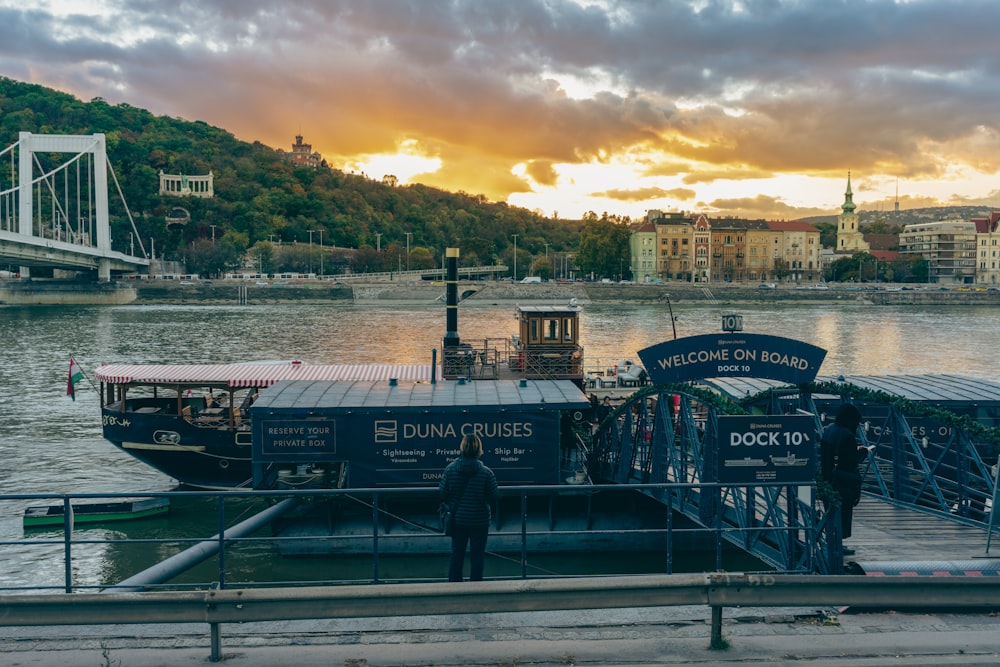 a boat is docked at a dock with a bridge in the background