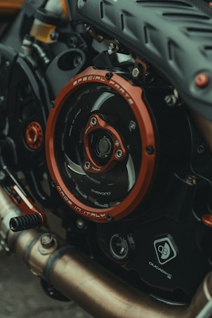 Close-up view of a motorcycle engine with a focus on the detailed components and branding. The metallic parts, including a prominently featured red circle marked with 'Special Parts' and 'Made in Italy', are contrasted with dark mechanical textures. Various elements like pipes and gears exhibit intricate design, reflecting craftsmanship and engineering.