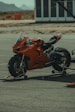 a red motorcycle parked on top of a parking lot