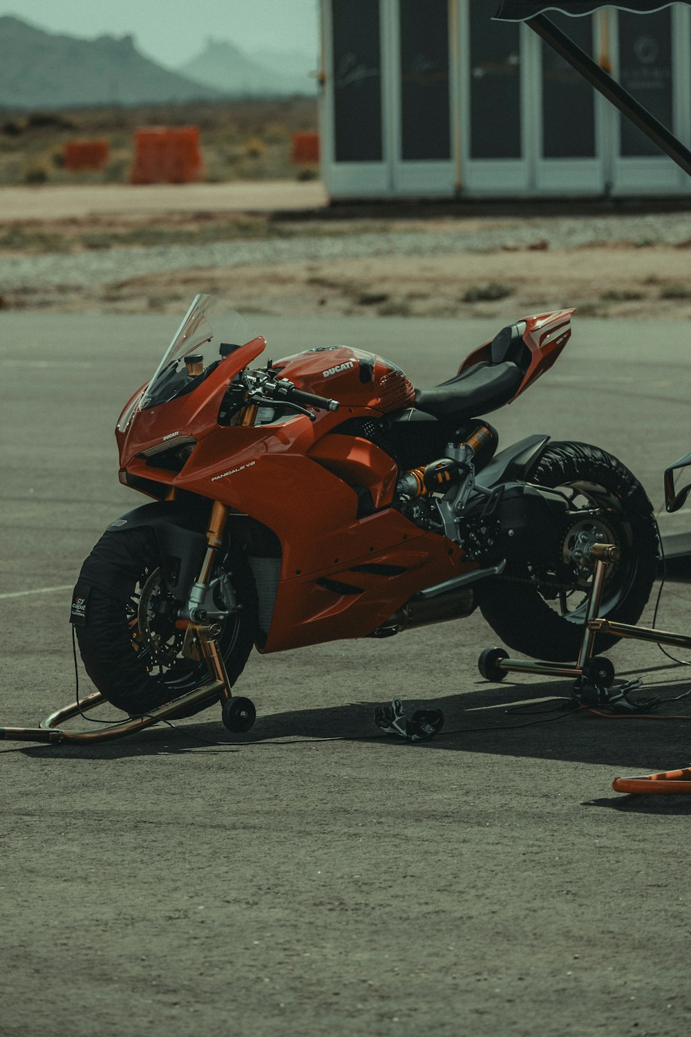 a red motorcycle parked on top of a parking lot