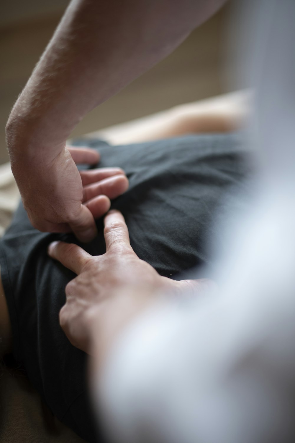 a person is touching another person's hand on a bed