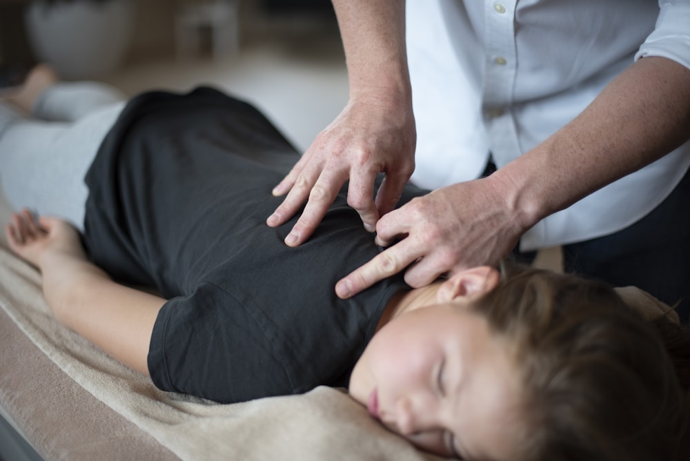 uma mulher recebendo uma massagem nas costas de um massageador