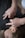 A person wearing a dark shirt is lying down, while another person's hands are pressing on their back or chest area. This seems to be either a massage or a therapy session.