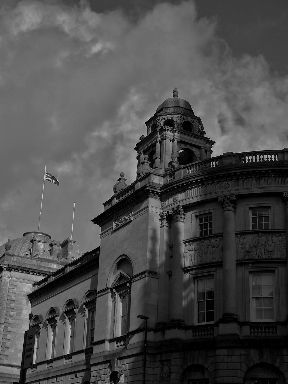 uma foto em preto e branco de um edifício com uma torre do relógio