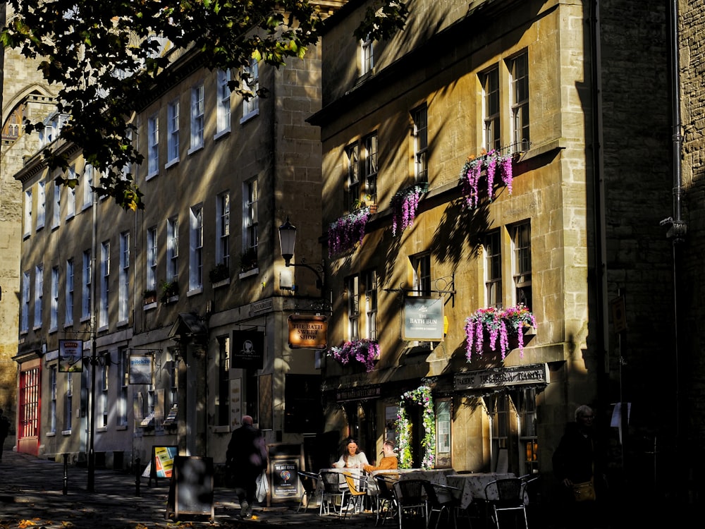 a couple of people sitting at a table in front of a building