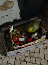 A large box brimming with assorted fruits and vegetables.