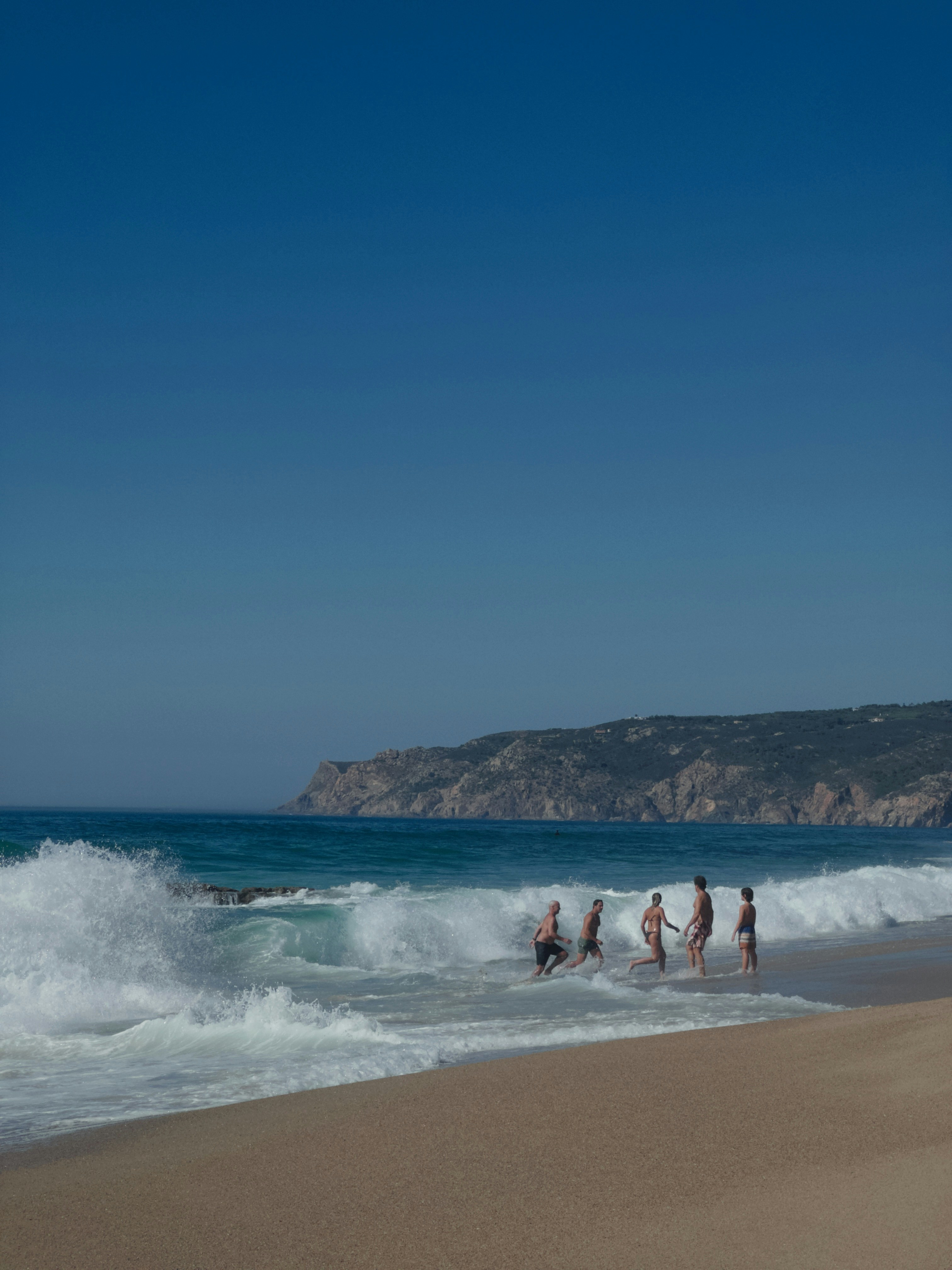 A group of people standing on top of a sandy beach photo – Free Travel ...