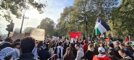 An outdoor rally with supporters holding banners and engaging in discussions.