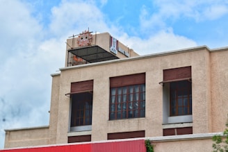 Modern Dunkin' Donuts building with drive-thru lane and vibrant branding on a sunny day.