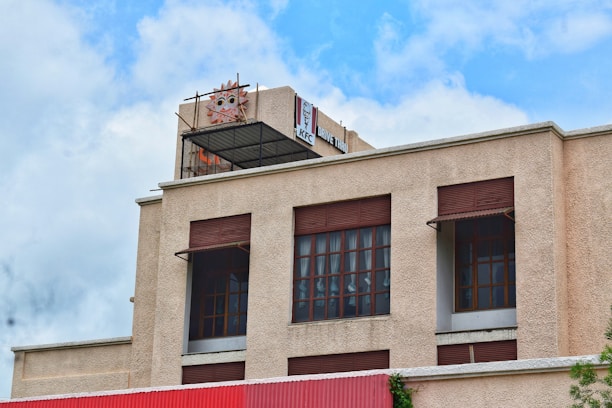 Modern Dunkin' Donuts building with drive-thru lane and vibrant branding on a sunny day.
