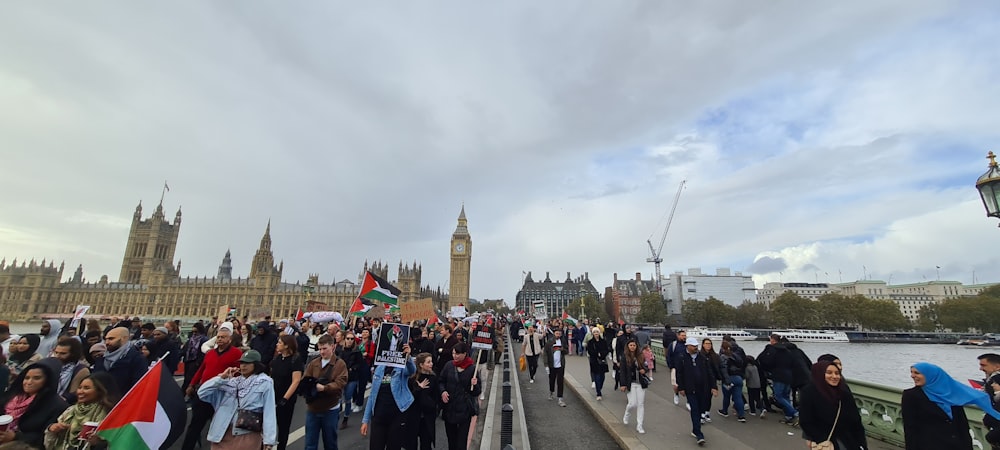 a large group of people walking across a bridge