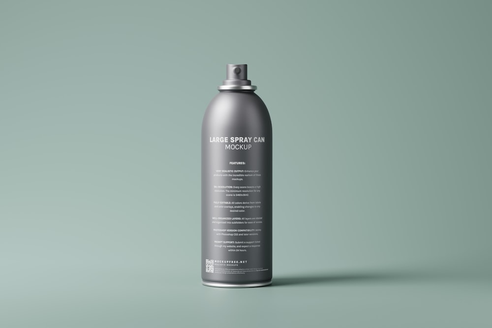 a gray spray can on a green background