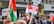 Crowd of people holding various protest signs and flags in front of McDonald's and Itsu restaurants. Some signs have messages related to stopping a massacre and proclaiming freedom for Palestine.