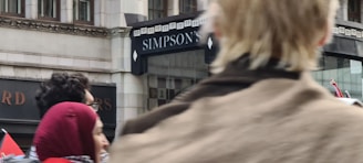 A friendly Simpson Insurance agent warmly greeting a family at the office entrance.