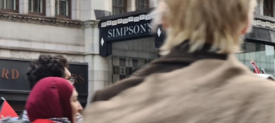 A friendly Simpson Insurance agent warmly greeting a family at the office entrance.