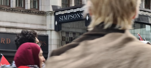 A friendly Simpson Insurance agent warmly greeting a family at the office entrance.