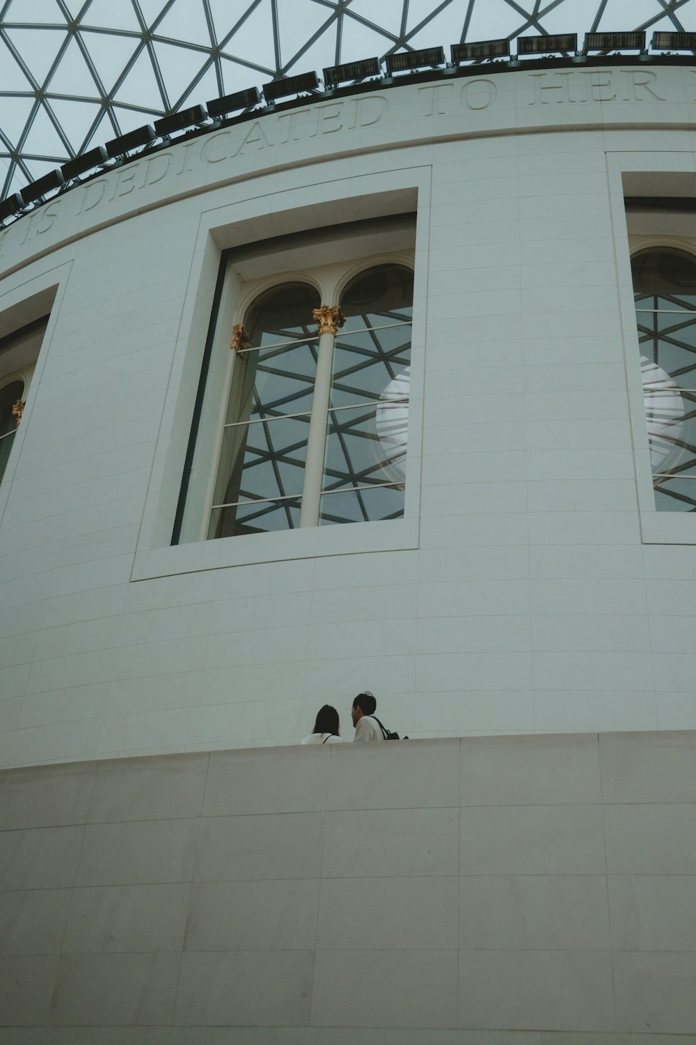 two birds sitting on the ledge of a building