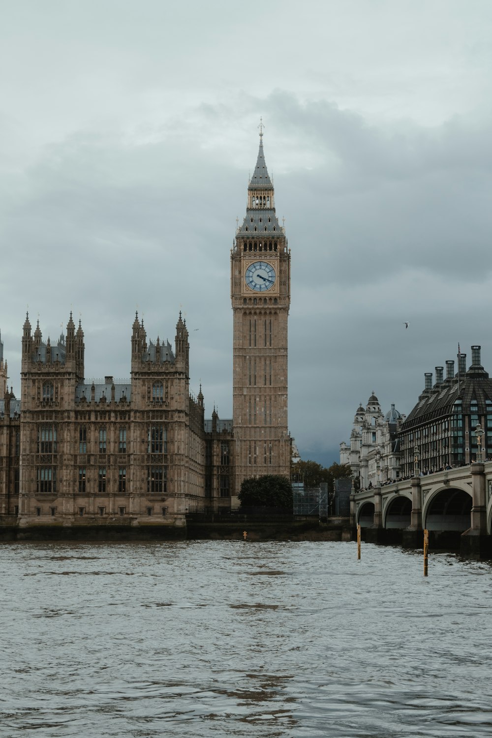 a large clock tower towering over a city next to a body of water